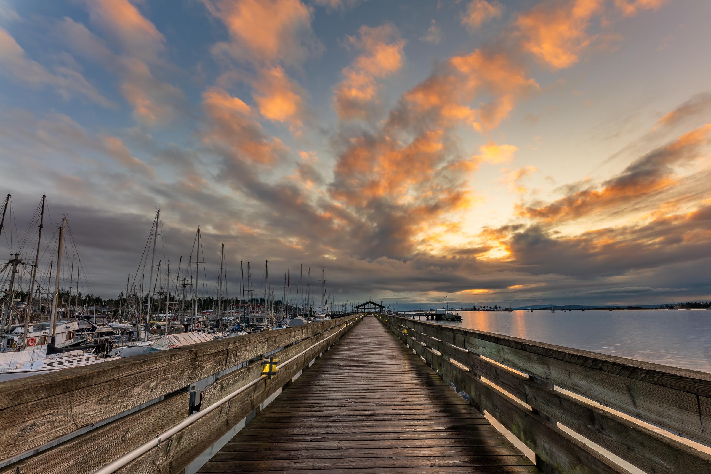 Fisherman's Wharf Boardwalk wall art showing sunrise over Goose Spit from the boardwalk railing, Comox Harbour, BC, by James Wheeler.